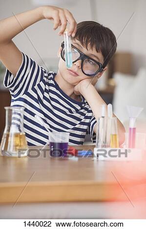 Boy wearing protective eyewear looking at test tube in house View Large Photo Image Stock Image - Boy wearing protective eyewear looking at test tube in house. Fotosearch