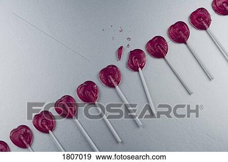 Broken heart-shape lollipop in a row View Large Photo Image Stock Photo - Broken heart-shape lollipop in a row. Fotosearch