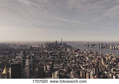 Stock Image - Buildings in Manhattan by river against sky seen from Empire State Building, New York City, USA. Fotosearch