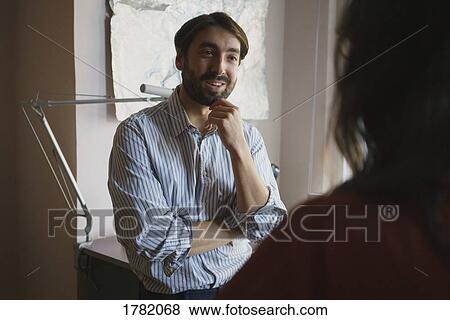 Businessman talking with colleague in office View Large Photo Image Stock Photo - Businessman talking with colleague in office. Fotosearch