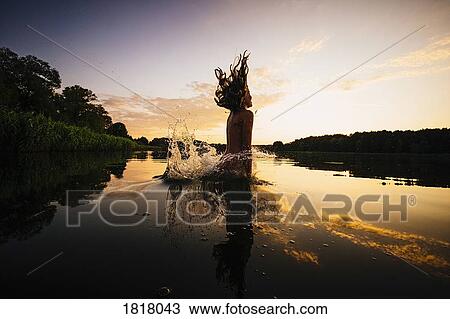 Carefree girl jumping into lake at sunset, Barnin, Mecklenburg-Vorpommern, Germany View Large Photo Image Stock Image - Carefree girl jumping into lake at sunset, Barnin, Mecklenburg-Vorpommern, Germany. Fotosearch