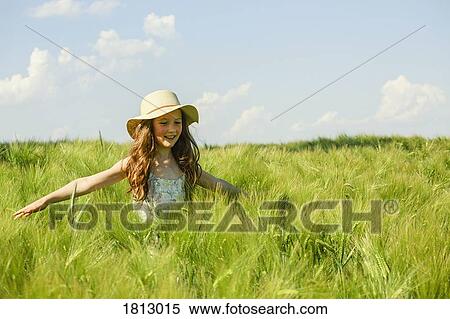 Carefree girl walking in sunny, idyllic green rural field View Large Photo Image Stock Photography - Carefree girl walking in sunny, idyllic green rural field. Fotosearch