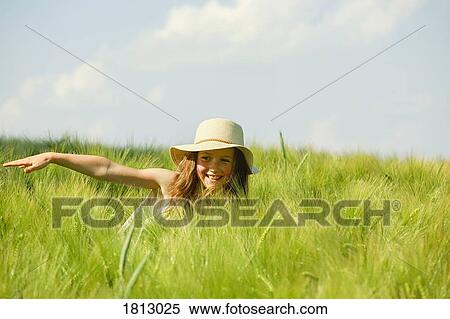 Carefree, happy girl in sunny rural green wheat field View Large Photo Image Stock Photography - Carefree, happy girl in sunny rural green wheat field. Fotosearch
