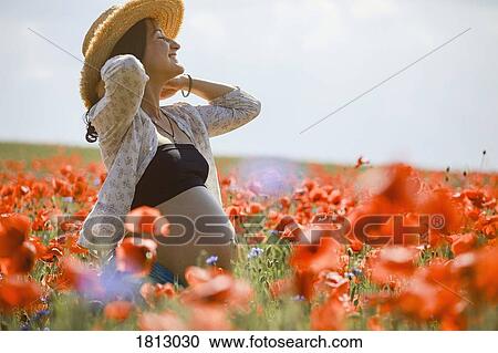 Carefree pregnant woman in sunny, idyllic rural red poppy field View Large Photo Image Stock Image - Carefree pregnant woman in sunny, idyllic rural red poppy field. Fotosearch