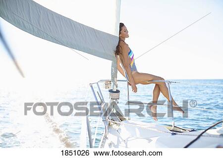 Carefree woman in bathing suit on sunny sailboat View Large Photo Image Stock Photograph - Carefree woman in bathing suit on sunny sailboat. Fotosearch