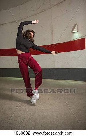 Carefree young woman dancing in tunnel View Large Photo Image Stock Image - Carefree young woman dancing in tunnel. Fotosearch