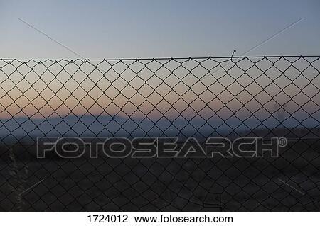 Chainlink fence on landscape against sky during sunset View Large Photo Image Stock Image - Chainlink fence on landscape against sky during sunset. Fotosearch