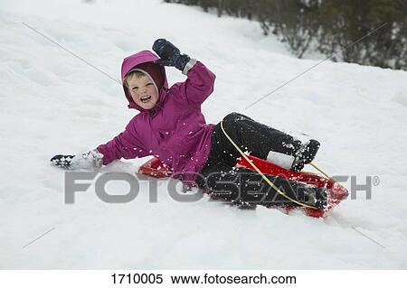 Cheerful boy tobogganing on snow covered field View Large Photo Image Stock Photography - Cheerful boy tobogganing on snow covered field. Fotosearch