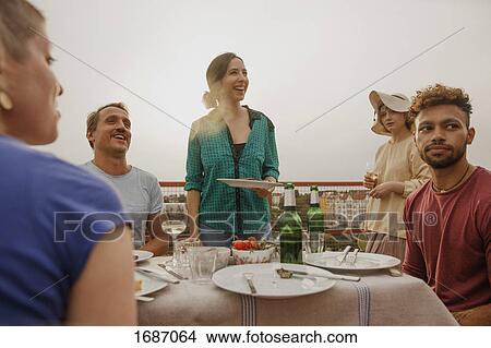 Cheerful friends enjoying lunch party on patio View Large Photo Image Picture - Cheerful friends enjoying lunch party on patio. Fotosearch