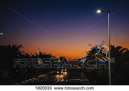 Christmas bell light decorations on street lamps over road at sunset, Costa Teguise, Lanzarote View Large Photo Image Stock Image - Christmas bell light decorations on street lamps over road at sunset, Costa Teguise, Lanzarote. Fotosearch