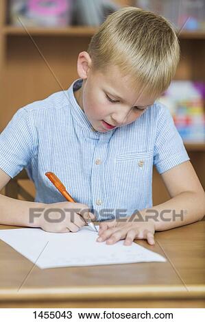 Close-up of boy writing on paper at table View Large Photo Image Stock Image - Close-up of boy writing on paper at table. Fotosearch