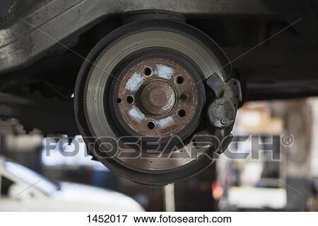 Stock Photo - Close-up of car machine part in garage. Fotosearch
