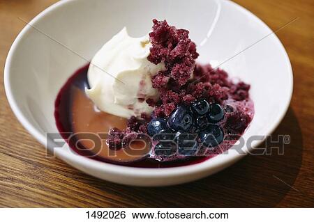 Stock Photograph - Close-up of dessert served in bowl on wooden table. Fotosearch
