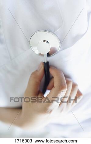 Stock Image - Close-up of doctor examining with stethoscope. Fotosearch