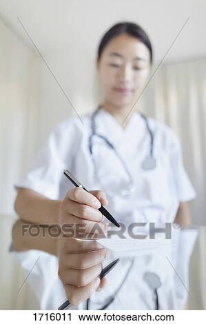 Close-up of female doctor writing prescription at table in clinic View Large Photo Image Stock Image - Close-up of female doctor writing prescription at table in clinic. Fotosearch