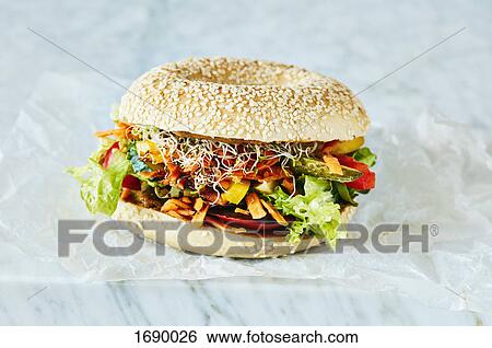 Stock Photograph - Close-up of fresh vegetarian burger on table. Fotosearch