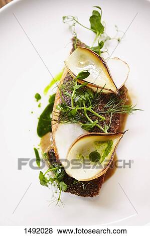 Stock Photo - Close-up of fried turbot fillet garnished with herbs on plate. Fotosearch
