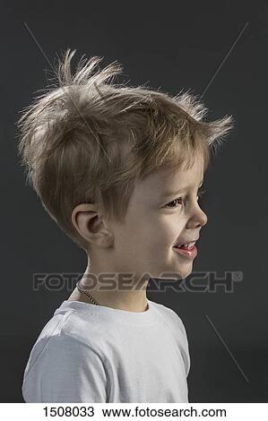 Stock Image - Close-up of happy boy against black background. Fotosearch