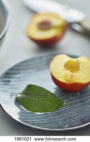 Close-up of leaf and halved peach in plate View Large Photo Image Stock Image - Close-up of leaf and halved peach in plate. Fotosearch