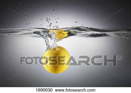 Stock Image - Close-up of lemon in splashing water. Fotosearch