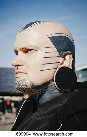 Close-up of man with tattoos and ear plug against sky View Large Photo Image Picture - Close-up of man with tattoos and ear plug against sky. Fotosearch