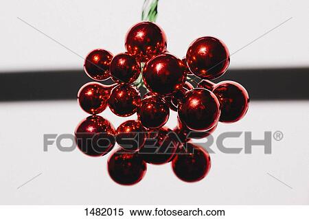 Stock Photography - Close-up of red shiny Christmas ornament against white background. Fotosearch