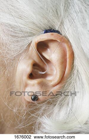 Close-up of senior woman's ear wearing hearing aid View Large Photo Image Stock Image - Close-up of senior woman's ear wearing hearing aid. Fotosearch