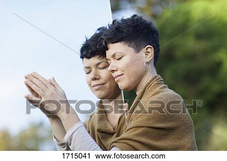 Close-up of smiling woman with closed eyes leaning on mirror at park View Large Photo Image Stock Image - Close-up of smiling woman with closed eyes leaning on mirror at park. Fotosearch