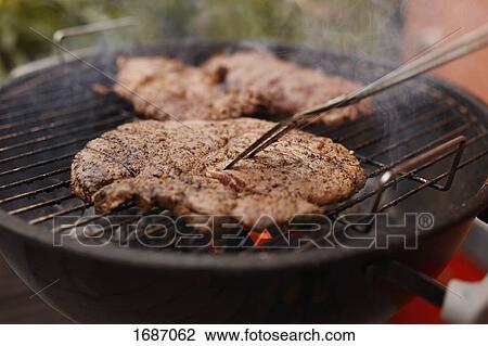 Close-up of steak being grilled on barbecue at patio View Large Photo Image Stock Image - Close-up of steak being grilled on barbecue at patio. Fotosearch