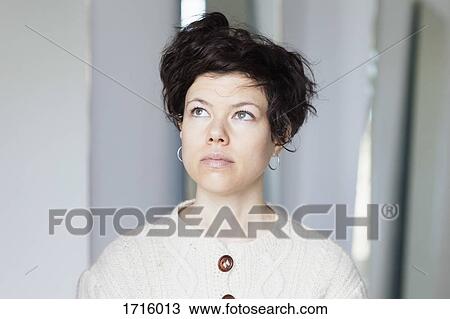 Stock Image - Close-up of thoughtful woman with short hair looking away. Fotosearch