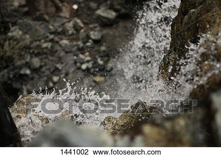 Stock Image - Close-up of water flowing over rocks. Fotosearch