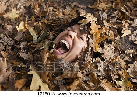 Close-up of woman shouting with closed eyes covered in dry leaves View Large Photo Image Stock Photo - Close-up of woman shouting with closed eyes covered in dry leaves. Fotosearch