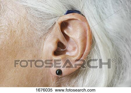 Close-up of woman with gray hair wearing hearing aid View Large Photo Image Stock Photography - Close-up of woman with gray hair wearing hearing aid. Fotosearch