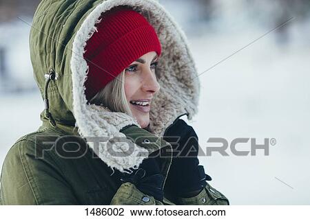 Stock Image - Close-up of young beautiful woman standing outdoors. Fotosearch