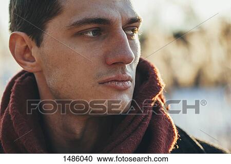 Stock Image - Close-up of young man standing outdoors. Fotosearch