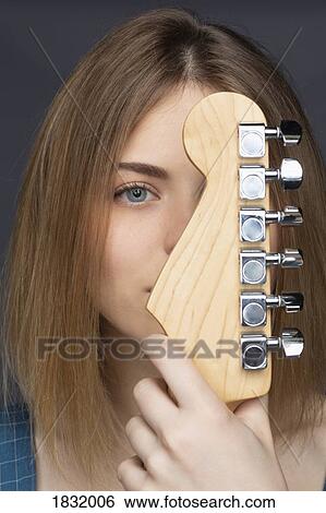 Stock Photograph - Close up portrait beautiful young woman with guitar. Fotosearch