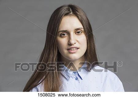 Close-up portrait of beautiful woman against gray background View Large Photo Image Stock Photography - Close-up portrait of beautiful woman against gray background. Fotosearch