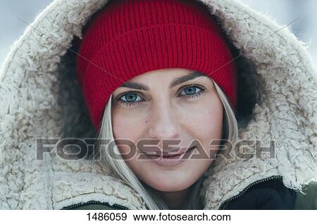Stock Photo - Close-up portrait of beautiful young woman wearing hood. Fotosearch