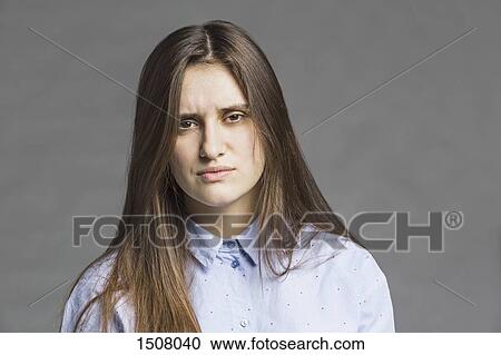 Close-up portrait of serious beautiful woman against gray background View Large Photo Image Stock Image - Close-up portrait of serious beautiful woman against gray background. Fotosearch