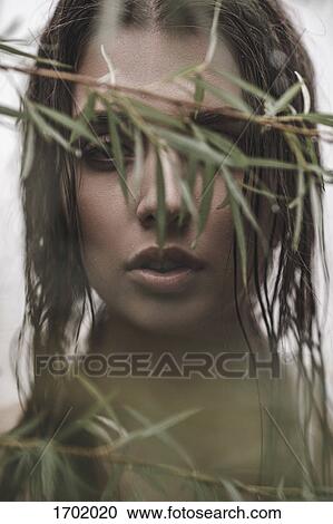 Close-up portrait of woman with wet hair looking through branches View Large Photo Image Stock Image - Close-up portrait of woman with wet hair looking through branches. Fotosearch
