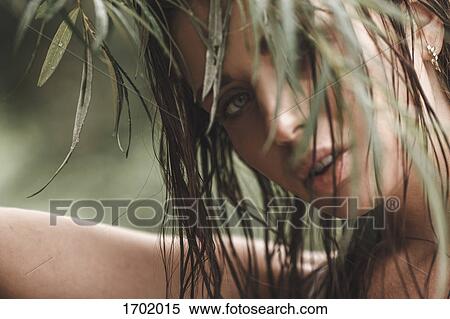 Close-up portrait of young woman with wet hair looking through leaves View Large Photo Image Stock Photography - Close-up portrait of young woman with wet hair looking through leaves. Fotosearch