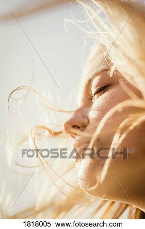Stock Photography - Close up serene woman enjoying wind and sunshine. Fotosearch