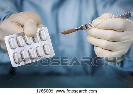 Close up surgeon holding scalpel and blister pack of pills View Large Photo Image Stock Photography - Close up surgeon holding scalpel and blister pack of pills. Fotosearch