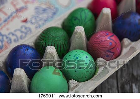 Close up vibrant colored Easter eggs in carton View Large Photo Image Stock Image - Close up vibrant colored Easter eggs in carton. Fotosearch
