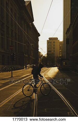 Commuter biking on sunny urban street, Berlin, Germany View Large Photo Image Stock Image - Commuter biking on sunny urban street, Berlin, Germany. Fotosearch