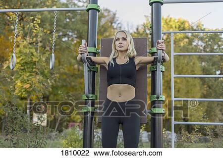 Confident, fit woman exercising in park View Large Photo Image Stock Image - Confident, fit woman exercising in park. Fotosearch