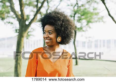 Confident, smiling young woman in sunny park View Large Photo Image Picture - Confident, smiling young woman in sunny park. Fotosearch