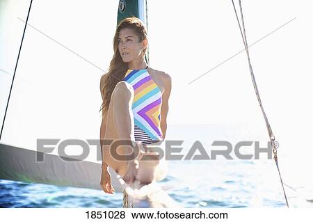 Confident woman in bathing suit on sunny sailboat View Large Photo Image Stock Photo - Confident woman in bathing suit on sunny sailboat. Fotosearch