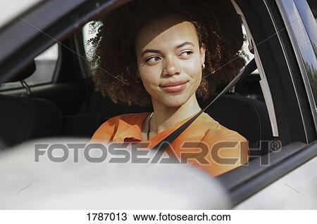 Confident young woman driving car View Large Photo Image Stock Image - Confident young woman driving car. Fotosearch