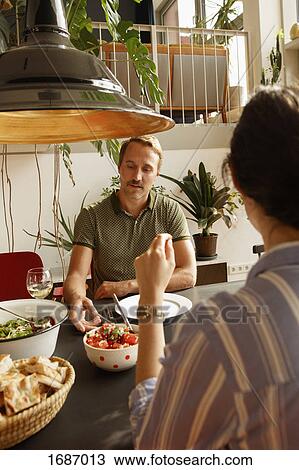 Couple having food at dining table in house View Large Photo Image Stock Image - Couple having food at dining table in house. Fotosearch